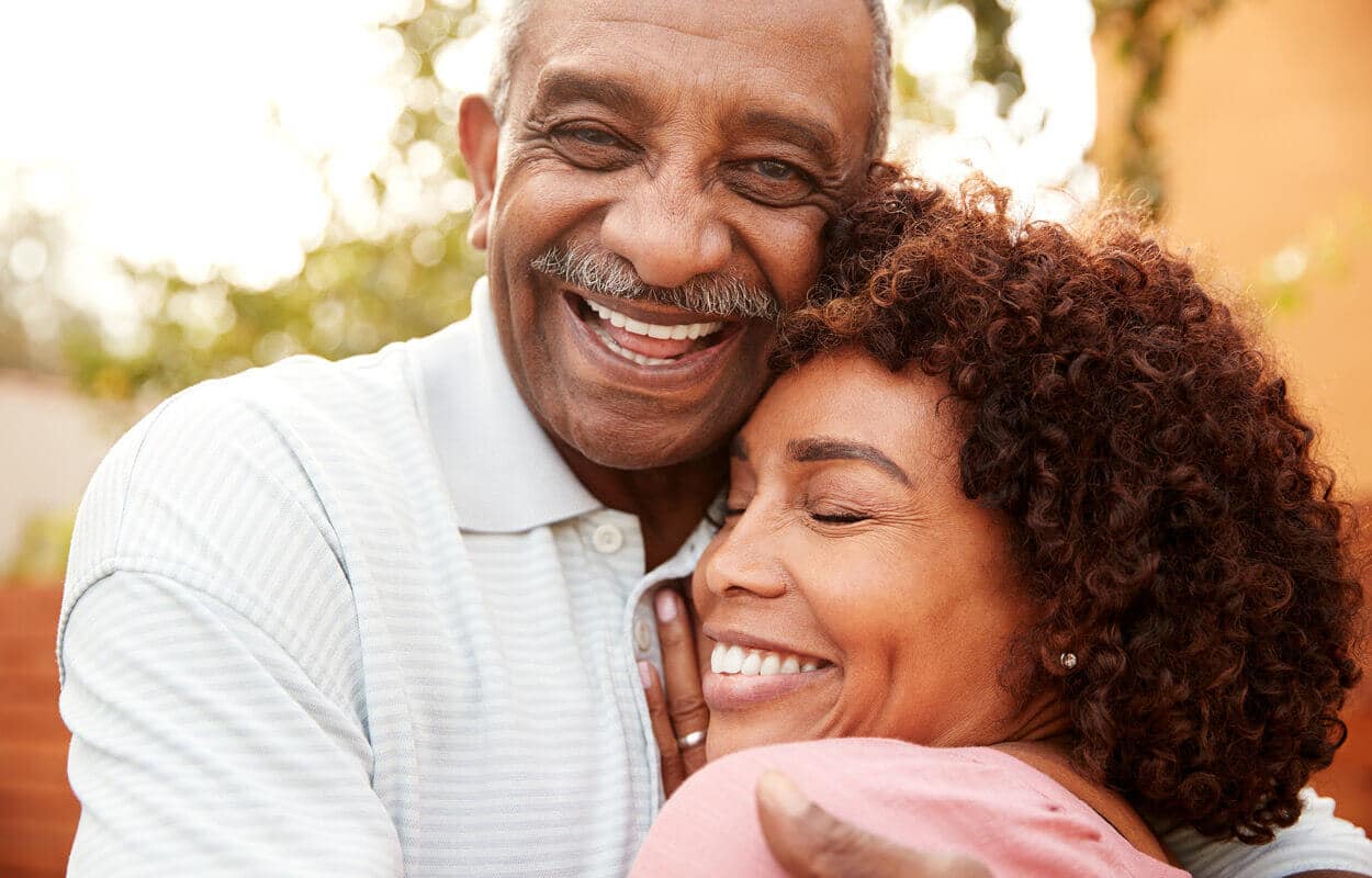 Senior man with daughter hugging and smiling