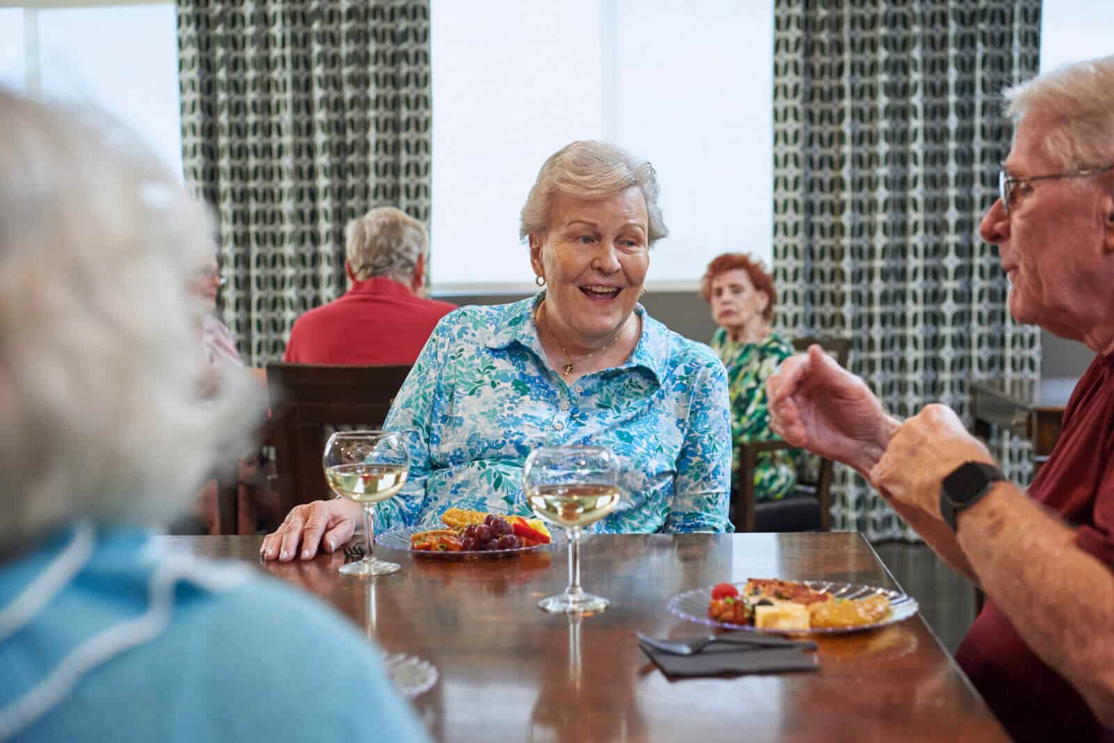 residents enjoying wine, cheese and friut