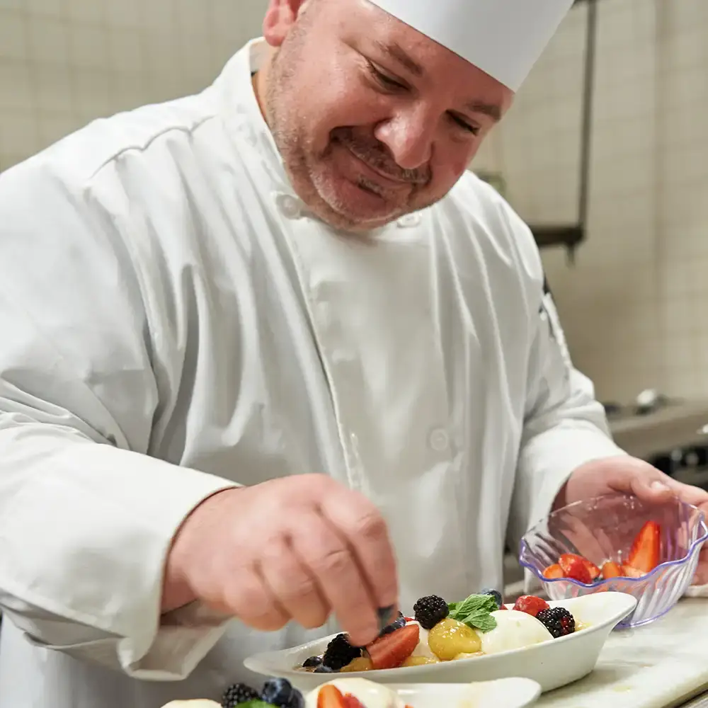 Chef Joe putting garnishes on a dessert dish