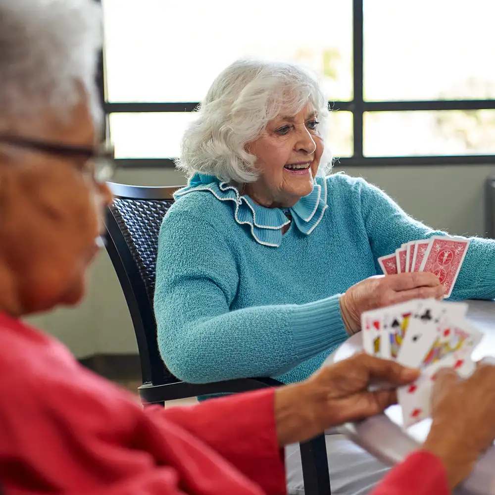 two senior residents playing a game of cards