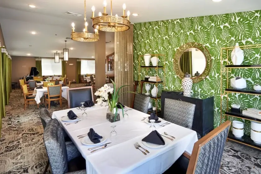 Dining room with green palm leaf wallpaper